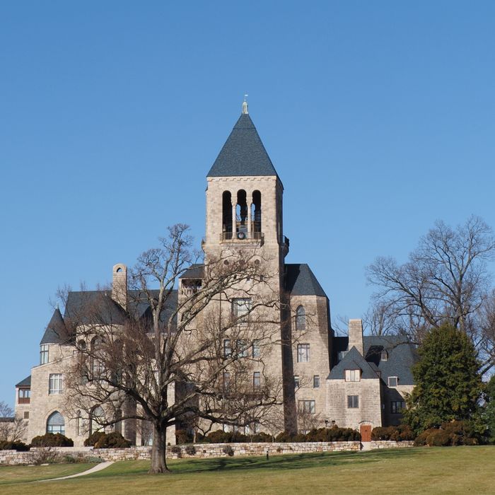 The Glencairn Museum tower in Bryn Athyn, PA stands against a clear blue sky, surrounded by winter trees.